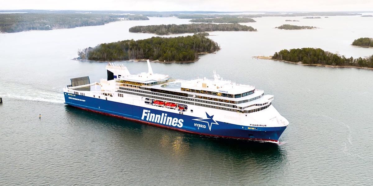 WeGo Groupin referenssin kansikuvana on Finnlinesin Finnsirius-hybridiristeilijä liikennöimässä saariston halki merellä, taustalla näkyy vehreitä saaria ja rauhallinen maisema.