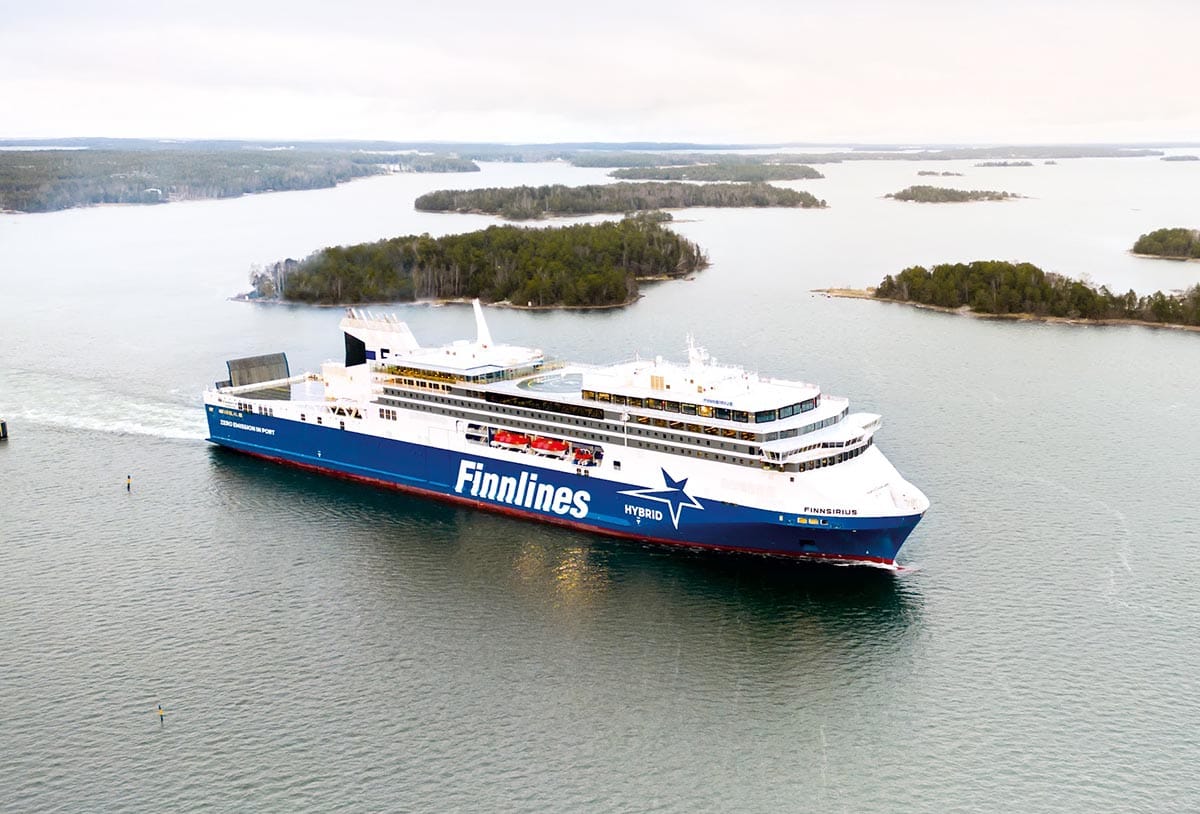 WeGo Groupin referenssin kansikuvana on Finnlinesin Finnsirius-hybridiristeilijä liikennöimässä saariston halki merellä, taustalla näkyy vehreitä saaria ja rauhallinen maisema.